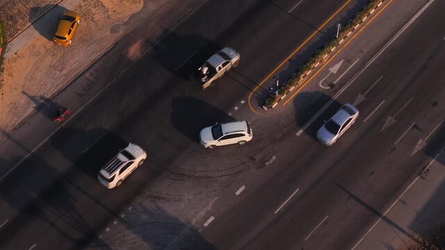 Aerial View of White Car waiting Performing Legal U Turn on Divided Highway at Designated Spot during heavy traffic motion