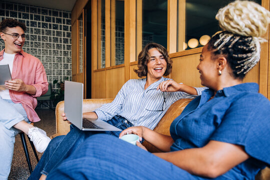 Group of professionals laughing and discussing ideas in a cozy office setting