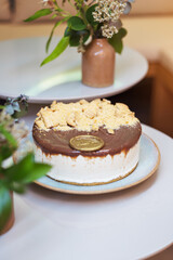 Cream and chocolate cake, decorated with ground peanuts, candy stores and bakeries