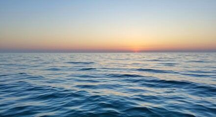 Obraz premium Peaceful seascape with gentle waves reflecting the golden light of the sunset horizon
