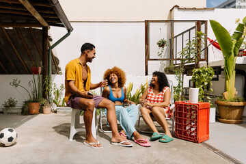 Three friends laughing and bonding in a sunny urban outdoor setting