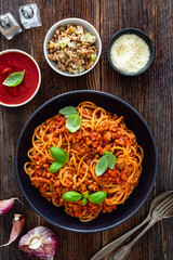 Spaghetti con ragù alla bolognese - pasta with minced meat and tomato sauce on wooden table