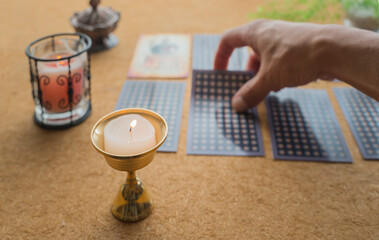 man's hand picking up a tarot card