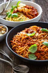 Spaghetti con ragù alla bolognese - pasta with minced meat and tomato sauce on wooden table