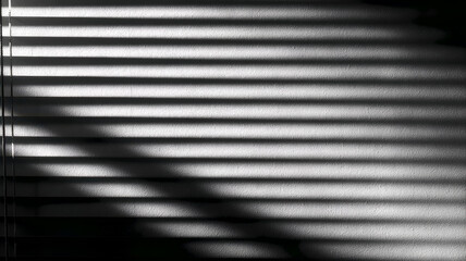 Monochrome striped shadows from blinds on textured wall