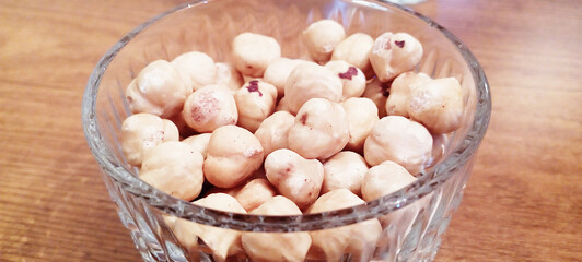 Raw hazelnuts without shells in a bowl on a white background