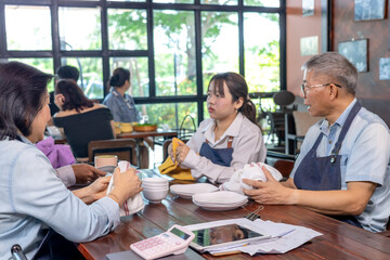 Small business restaurant owner senior couple using tablet planning management discussion technology, husband and wife teamwork, startup coaching staff, Asian dining business leadership lifestyle