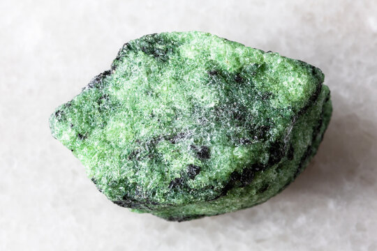 sample of raw zoisite rock on white marble