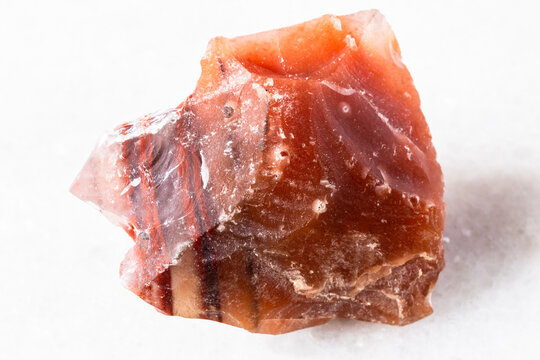raw carneol chalcedony rock on white marble