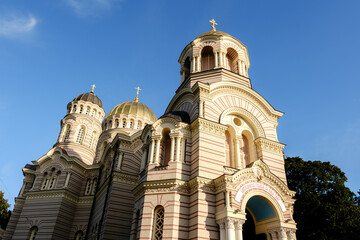 Captivating view of the Nativity of Christ Cathedral in Riga, Latvia, showcasing its intricate red and white brick design. The majestic domes reflect the rich history and culture of the Baltic city.