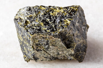 sample of raw diopside mineral on white marble