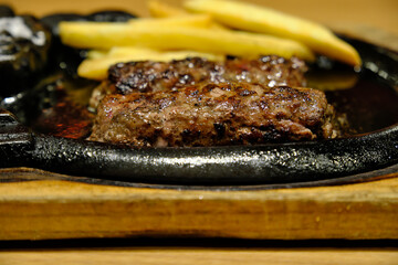 A Juicy Hamburg Steak Sizzling on a Hot Cast-Iron Platter