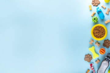 Flat lay composition with food, snacks, toys and accessories for dog and cat on bright background. Pet care, dog shopping and sale concept top view copy space