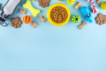 Flat lay composition with food, snacks, toys and accessories for dog and cat on bright background. Pet care, dog shopping and sale concept top view copy space