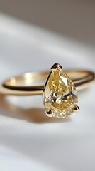 Elegant PearShaped Yellow Diamond Solitaire Ring in Gold Setting CloseUp on White Background