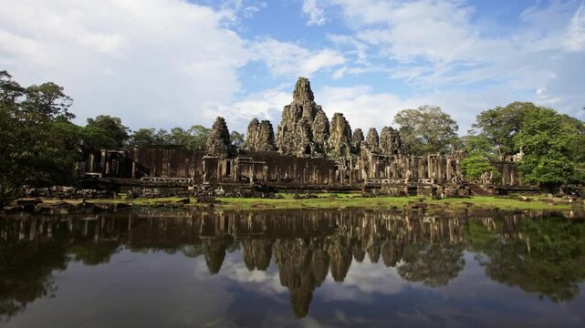 The ancient bayon temple reflecting in the water in angkor, cambodia