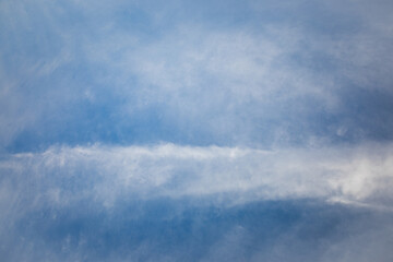 Clear blue sky with soft white clouds creating a calm and airy atmosphere, perfect for backgrounds, nature themes, or abstract environmental concepts.