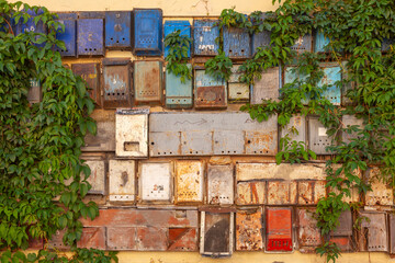 Various old mailboxes on the wall of a house. Some have the Russian inscription "Post Office" on them