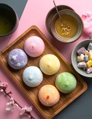 Flat Lay of Japanese Mochi Desserts in Assorted Colors with Powdered Sugar on Neutral Background