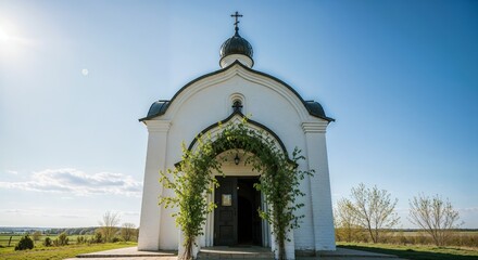 Orthodox chapel with cross and arched entrance decorated with greenery on clear blue sky background