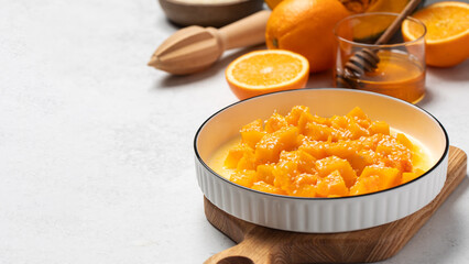 Healthy dessert with sliced pumpkin, honey and orange juice in a bowl. Pumpkin dish. Copy space