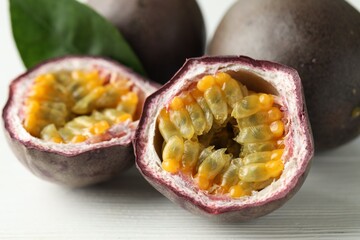 Fresh passion fruits on white wooden table, closeup