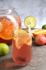 Punch and fresh fruits on grey table, closeup. Refreshing drink