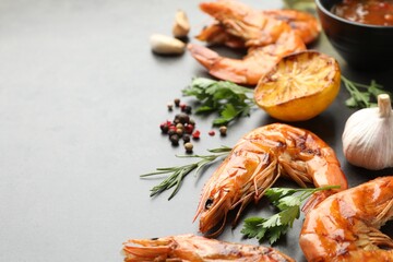 Delicious seafood dish. Tasty grilled shrimps with spices on grey table, closeup. Space for text