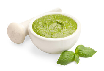 Mortar of fresh pesto sauce, basil and pestle isolated on white