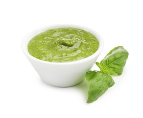 Pesto sauce in bowl and fresh basil leaves isolated on white