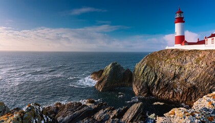 striking red and white lighthouse perched atop rocky cliffs overlooking the ocean a serene coastal landscape under a