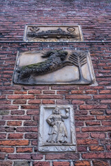 Old brick wall with old Dutch facing bricks and stone tablets in the historic center of Amsterdam, The Netherlands, Europe