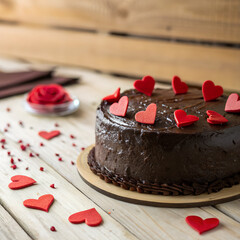 chocolate cake with hearts on a wooden background.