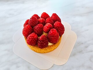 Raspberry tartlet on a white background. Large raspberries on a French dessert, isolated, close-up.
