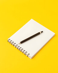 notebook and pen isolated on yellow background