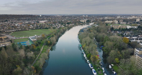 London city , Teddington: River Thames winding through Teddington, showcasing moored boats,...