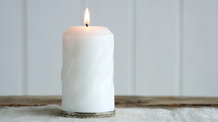 White Candle Flickering Softly on a Natural Fabric Surface With a Neutral Backdrop