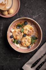 Delicious syrniki pancakes with blueberries, walnuts and mint leaves