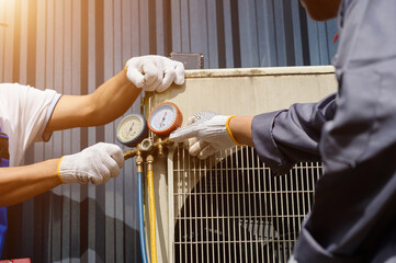 Close-up of an air conditioner technician adjusting a gauge on an outdoor AC unit, a professional...
