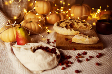 Autumn Thanksgiving Table Scene With Pumpkins, Pear, Pie On Wooden Board And Warm Fairy Lights