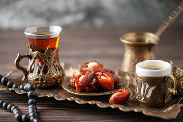 Cup of coffee and glass of tea and dry dates stuffed almonds on saucer ready to eat for iftar time....
