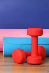 Colorful fitness equipment with red dumbbells and yoga mats