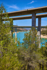 Tranquil scenery under a bridge over a reservoir with crystal clear turquoise water
