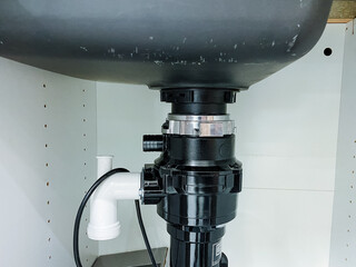 A kitchen sink that has a garbage disposal unit installed underneath it for grinding food waste, making it easier to dispose of leftovers and keep the kitchen clean and organized