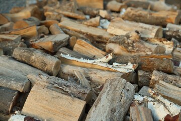 Pile of cut firewood outdoors, closeup view