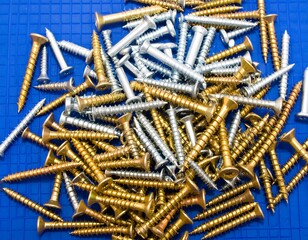 Pile of assorted screws on blue background