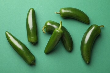 Ripe jalapeno peppers on green background, flat lay