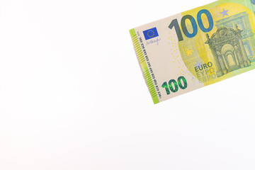 Close-up of a 100 euro banknote on a white background, symbolizing finance, wealth, savings, currency, or economic value.