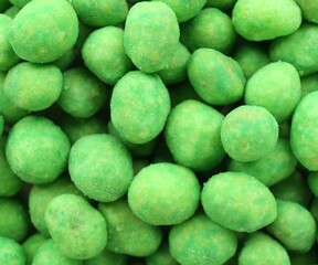 Tasty wasabi coated peanuts as background, closeup