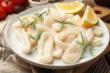 Uncooked squid rings, spices and tomatoes on table, closeup